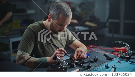 Worker With Tattoo on Arm Soldering Internal Electronics Onto Contemporary Drone Frame Worker With Tattoo on Arm Soldering Internal Electronics Onto Contemporary Drone Frame 133765024