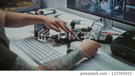 Man Hands on Assembling and Connecting Motor Systems of FPV Drone, With Digital Interface Visible 133765053