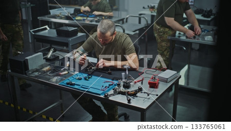 Technician Performing Intricate Repair and Maintenance of FPV Drone Electronics Technician Performing Intricate Repair and Maintenance of FPV Drone Electronics 133765061