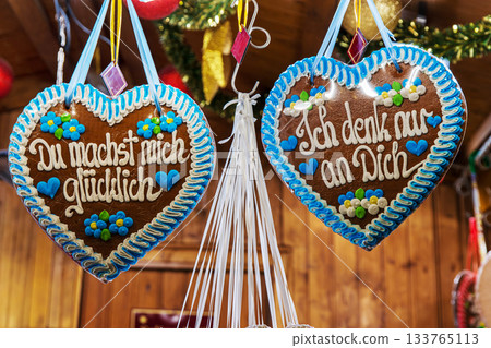 Du machst mich gluecklich und ich denk nur an dich. You make me happy, I am thinking of you messages in German. Lebkuchenherzen hang side by side in a festive christmas market stall. Du machst mich gluecklich und ich denk nur an dich. You make me happy, I am thinking of you messages in German. Lebkuchenherzen hang side by side in a festive christmas market stall. 133765113