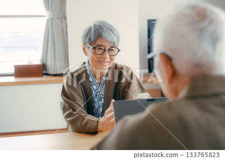 一對老年夫婦在傳統的日式旅館用智慧型手機拍攝風景。 一對老年夫婦在傳統的日式旅館用智慧型手機拍攝風景。 133765823