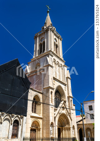 Vertical view of the Gothic Revival tower of the Church of the Sacred Hearts in Valparaiso, Chile. The historic stone building stands against a deep blue sky near Parque Italia 133765824