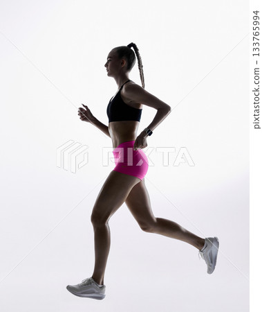 Female athlete jogging in clean minimal studio light Female athlete jogging in clean minimal studio light 133765994