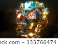 Glowing gemstone skull resting on dark surface with intricate details 133766474
