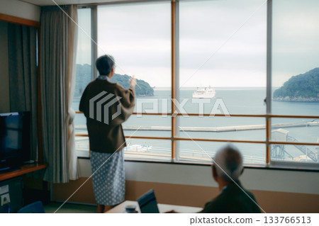 一對老年夫婦在傳統旅館的日式房間拍攝風景照。 133766513