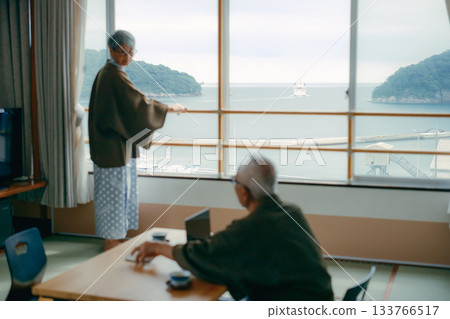 一對老年夫婦在傳統旅館的日式房間拍攝風景照。 133766517