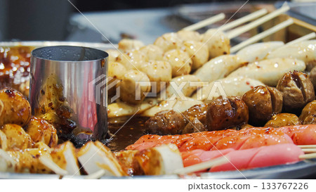 Thai Grilled Meatballs and Sausages (Look Chin Ping) served with sweet and spicy sauce. Famous Bangkok street food. 133767226