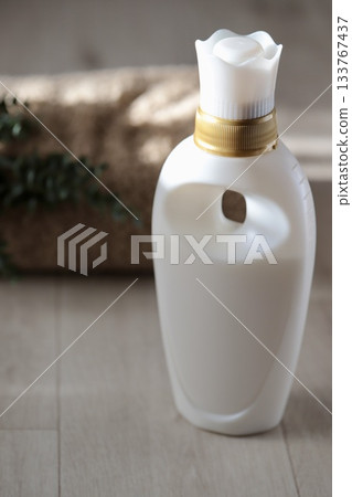 White fabric softener container and bath towel White fabric softener container and bath towel 133767437