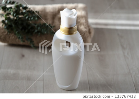 White fabric softener container and bath towel 133767438