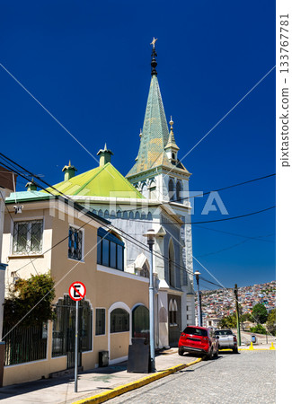 Lutheran Church of The Holy Cross in Valparaiso, Chile. The historic church with a tall spire stands on Cerro Concepcion under a deep blue sky Lutheran Church of The Holy Cross in Valparaiso, Chile. The historic church with a tall spire stands on Cerro Concepcion under a deep blue sky 133767781
