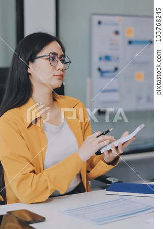 Business woman using calculator for do math finance on wooden desk in office and business working background, tax, accounting, statistics and analytic research concept. Business woman using calculator for do math finance on wooden desk in office and business working background, tax, accounting, statistics and analytic research concept. 133768245