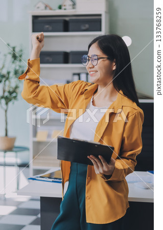 Business woman using calculator for do math finance on wooden desk in office and business working background, tax, accounting, statistics and analytic research concept. 133768259