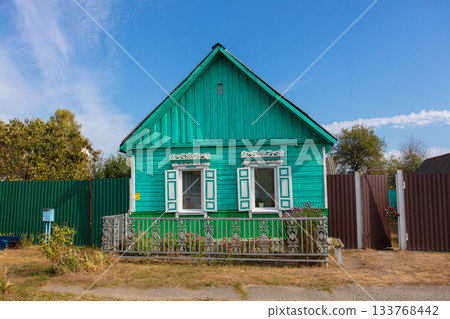 One-story Russian village house with carved shutters. 133768442