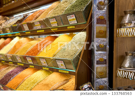 A colorful display of various spices in a market setting, showcasing a variety of aromatic ingredients. 133768563