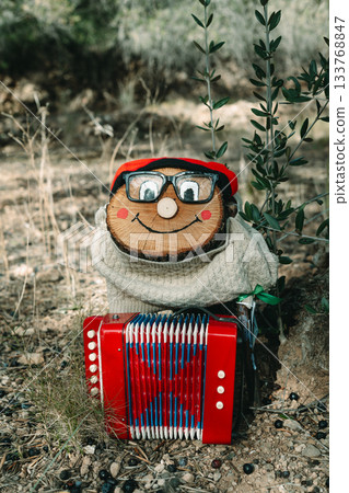 a Tio de Nadal standing with a red accordion a Tio de Nadal standing with a red accordion 133768847