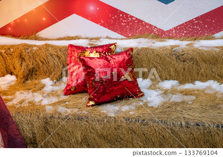 Festive red sequin pillows on straw with snowflakes and holiday decor 133769104