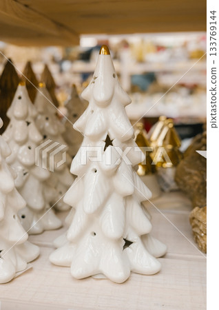 White ceramic christmas trees with star cutouts in festive display White ceramic christmas trees with star cutouts in festive display 133769144