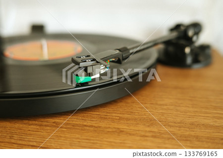 Close-up of vinyl record playing on turntable with focus on tonearm Close-up of vinyl record playing on turntable with focus on tonearm 133769165