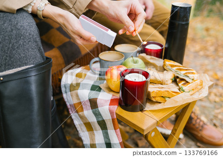 Cozy autumn picnic with candle, apples, and sandwiches Cozy autumn picnic with candle, apples, and sandwiches 133769166