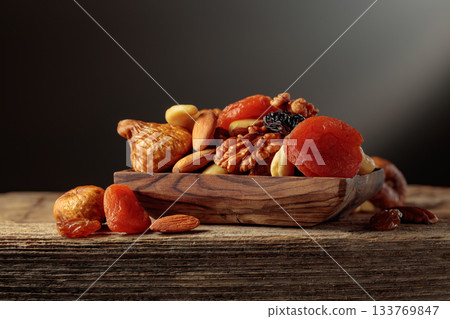 Dried fruits and nuts on a old wooden table. 133769847