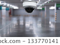 CCTV dome camera in empty parking garage with reflective floor and blurred background 133770141