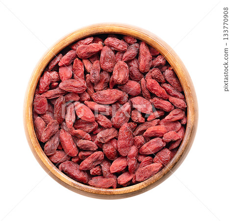 Dried goji berries, in a wooden bowl. Also known as Chinese wolfberry, red medlar, and matrimony vine. Bright orange-red sweet fruits of the shrub Lycium barbarum, native to China and across Asia. Dried goji berries, in a wooden bowl. Also known as Chinese wolfberry, red medlar, and matrimony vine. Bright orange-red sweet fruits of the shrub Lycium barbarum, native to China and across Asia. 133770908