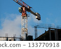 Control Cabin and Counterweight of Red Tower Crane at Construction Site. Monolithic Box with Window Holes and Rebar outlets against Blue Sky background. 133770918