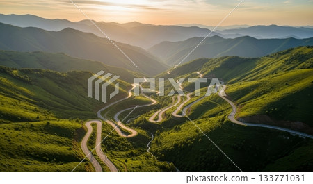 Serene Winding Road Through Lush Green Mountains at Dusk 133771031