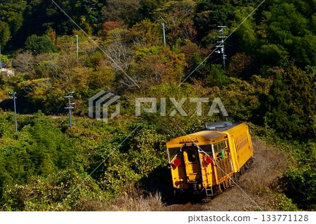 一輛黃色電車駛過山村的彎道 一輛黃色電車駛過山村的彎道 133771128