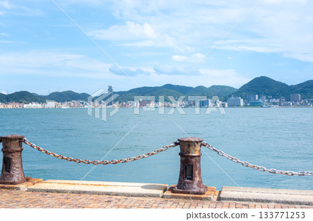 Shimonoseki's seaside promenade overlooking the Kanmon Strait and Kanmon Bridge and the blue summer sky 133771253