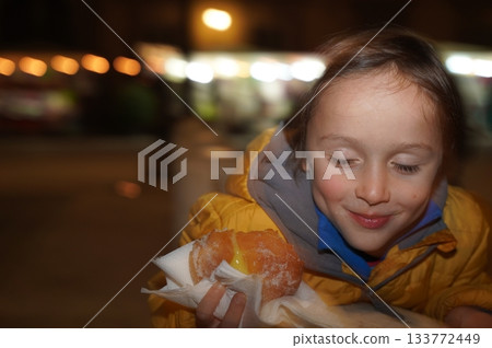 Child Enjoys Sweet Pastry at Night Market Child Enjoys Sweet Pastry at Night Market 133772449
