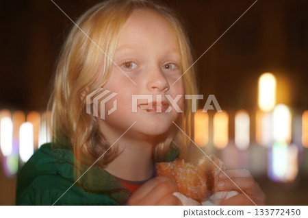 Child Enjoying a Sugary Treat with Chocolate Smudges 133772450