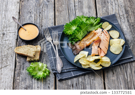 hot smoked trout fillet with lettuce, potato chips hot smoked trout fillet with lettuce, potato chips 133772581
