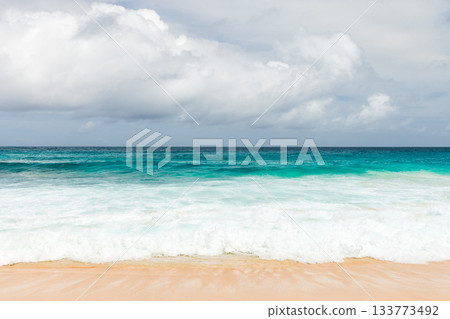 A pristine beach scene featuring turquoise sea, white surf and warm sand A pristine beach scene featuring turquoise sea, white surf and warm sand 133773492