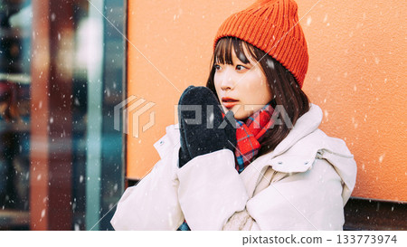 一位女子站在雪中的街角 一位女子站在雪中的街角 133773974