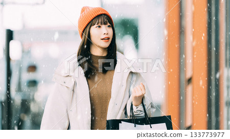 一位女士在白雪皚皚的冬日城市購物 133773977