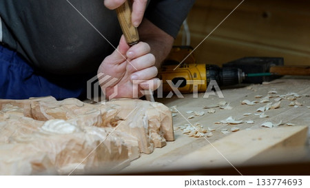 Chisel work highlighting craftsmanship details, Refining carved surface with precise hand tools and wood textures, Artist shaping wood surface with chisel amid chips and textured grains Chisel work highlighting craftsmanship details, Refining carved surface with precise hand tools and wood textures, Artist shaping wood surface with chisel amid chips and textured grains 133774693