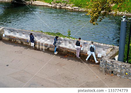 Pilgrims to the Sanctuary of Lourdes in France filling up bottle 133774779