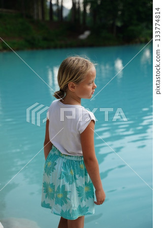Young Girl Enjoying Peaceful Lake View in Nature 133774814