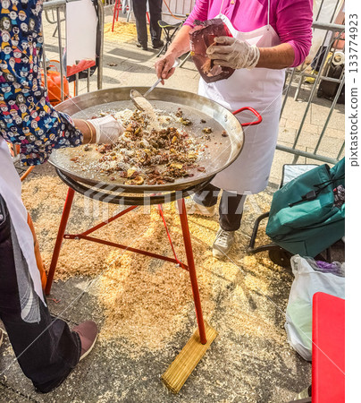 Chefs Preparing Paella in a Large Outdoor Paella Pan Chefs Preparing Paella in a Large Outdoor Paella Pan 133774923