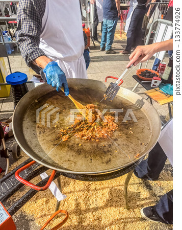 Chefs Preparing Sofrito Base for Paella Outdoors 133774926