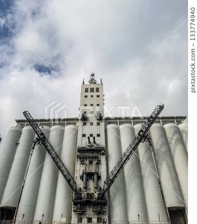 Monumental White Grain Silos with Industrial Loading Cranes Monumental White Grain Silos with Industrial Loading Cranes 133774940
