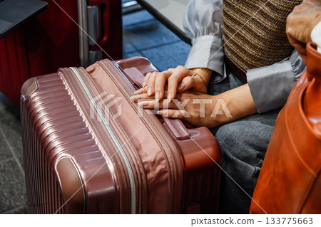 特寫鏡頭:一位旅行者雙手放在行李箱上。 特寫鏡頭:一位旅行者雙手放在行李箱上。 133775663
