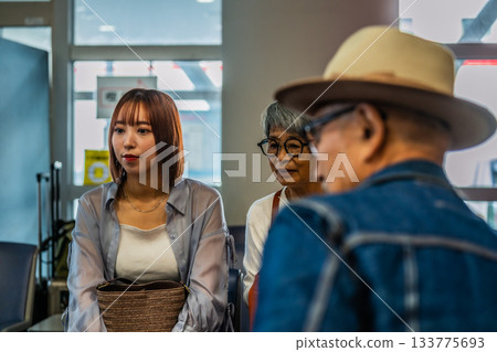 A young and elderly couple talking in the waiting room A young and elderly couple talking in the waiting room 133775693