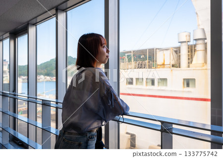 Young woman looking out the window of a ferry Young woman looking out the window of a ferry 133775742