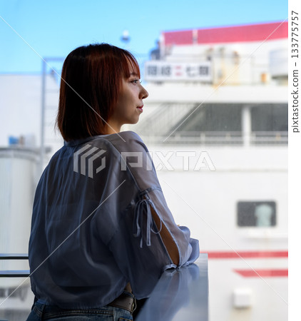 一位年輕女子正望著船窗外。 133775757