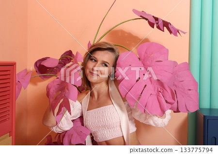 Contemplative female subject amid gentle pink botanical scenery Contemplative female subject amid gentle pink botanical scenery 133775794