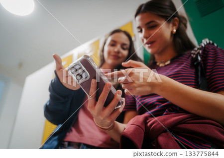 Teen students hanging out in school hallway by lockers. 133775844