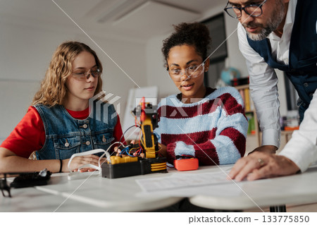 High school students working on robotics project with their teacher. High school students working on robotics project with their teacher. 133775850