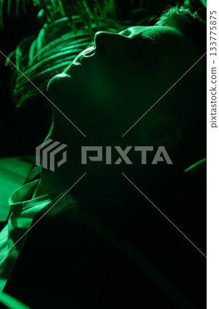 Tranquil individual facing upward surrounded by soothing plant outlines Tranquil individual facing upward surrounded by soothing plant outlines 133775875